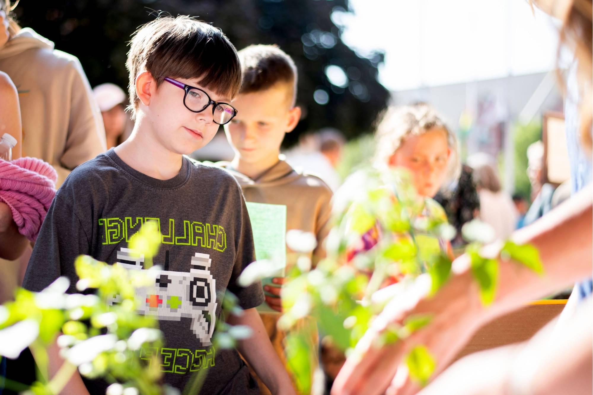 Student looking at plants at the Groundswell Student Project Showcase